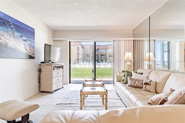 living room featuring light tile patterned floors, a textured ceiling, and plenty of natural light