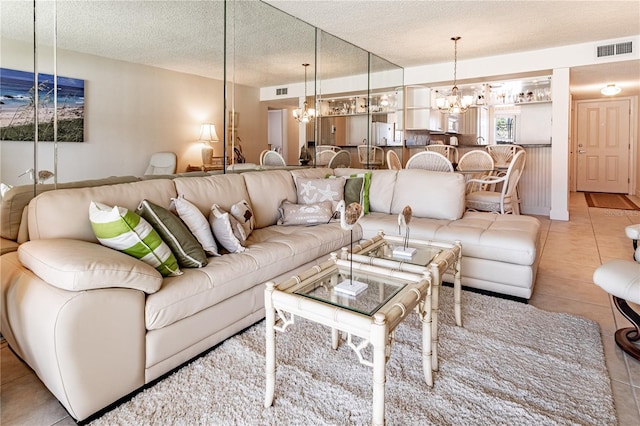 tiled living room with a textured ceiling and a chandelier