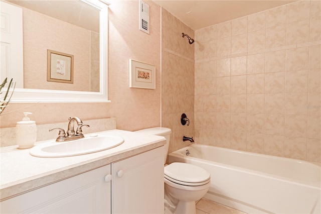 full bathroom featuring vanity, tiled shower / bath combo, toilet, and tile patterned flooring