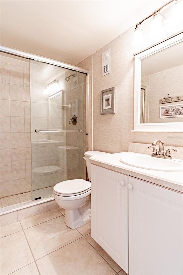 bathroom featuring tile patterned flooring, vanity, toilet, and an enclosed shower