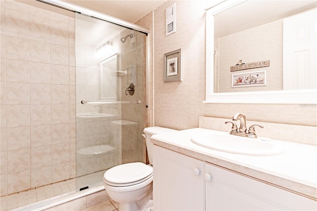 bathroom with tile patterned floors, vanity, an enclosed shower, and toilet