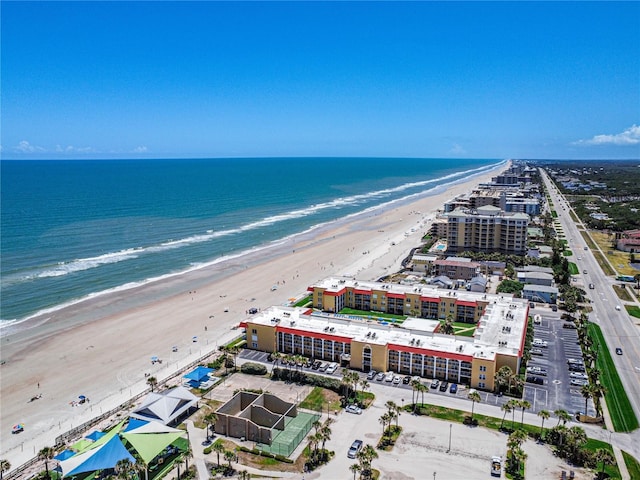 birds eye view of property with a water view and a beach view