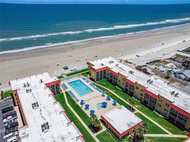 birds eye view of property with a water view and a beach view