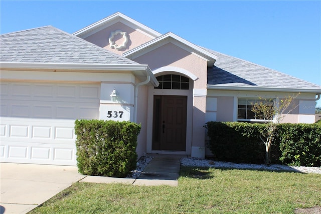 view of front of property with a front yard and a garage