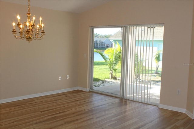 interior space with hardwood / wood-style floors, vaulted ceiling, and a chandelier