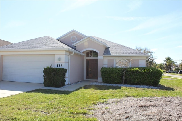 single story home featuring a garage, a shingled roof, concrete driveway, a front lawn, and stucco siding