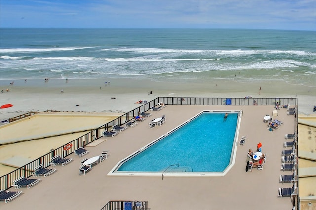 view of pool with a water view and a view of the beach