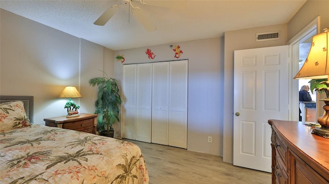 bedroom with light hardwood / wood-style flooring, a closet, and ceiling fan