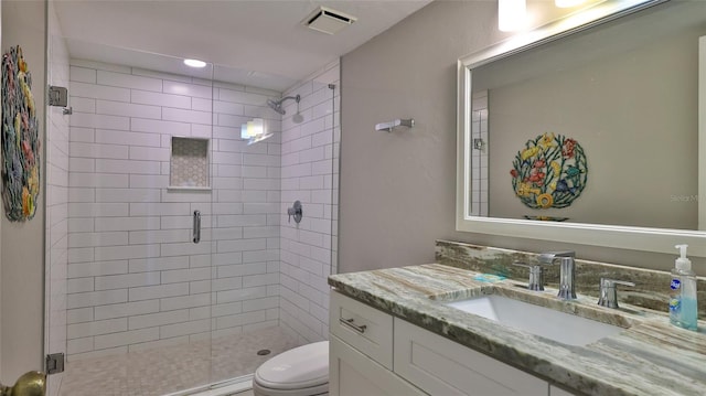 bathroom featuring vanity, toilet, and a shower with shower door