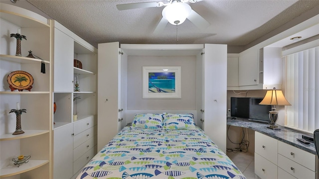 bedroom featuring ceiling fan, light tile patterned floors, and a textured ceiling