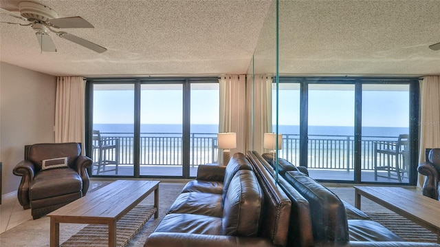 living room with a wall of windows, a water view, and a wealth of natural light