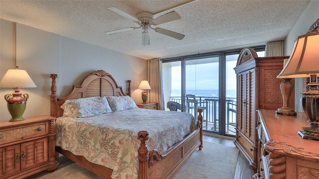 bedroom with access to exterior, ceiling fan, a wall of windows, light hardwood / wood-style floors, and a water view