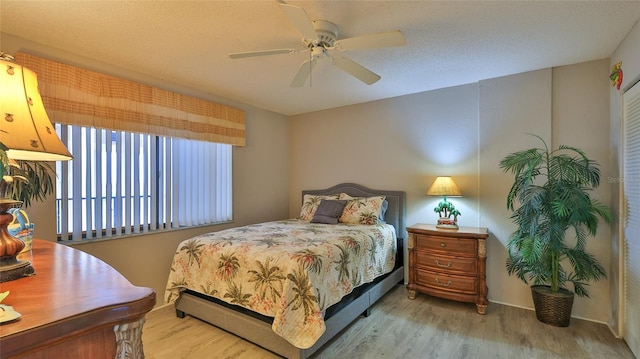 bedroom with wood-type flooring, a textured ceiling, and ceiling fan