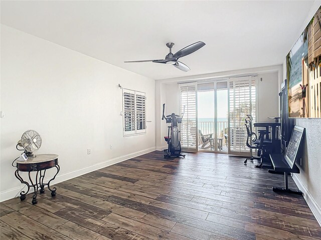 exercise room with ceiling fan and dark hardwood / wood-style flooring