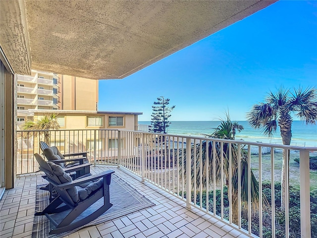 balcony featuring a water view and a view of the beach