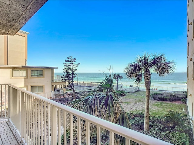 balcony with a water view and a view of the beach