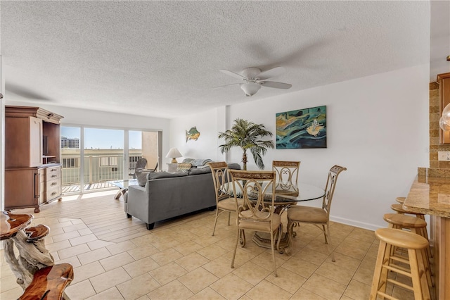 dining room with ceiling fan, light tile patterned flooring, and a textured ceiling