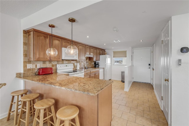 kitchen featuring kitchen peninsula, tasteful backsplash, white appliances, sink, and pendant lighting