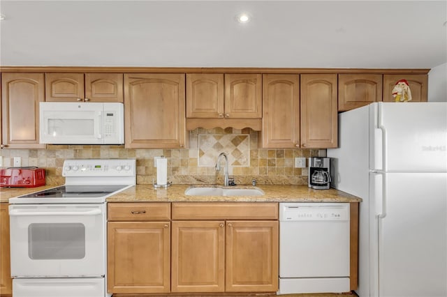 kitchen featuring decorative backsplash, sink, light stone countertops, and white appliances