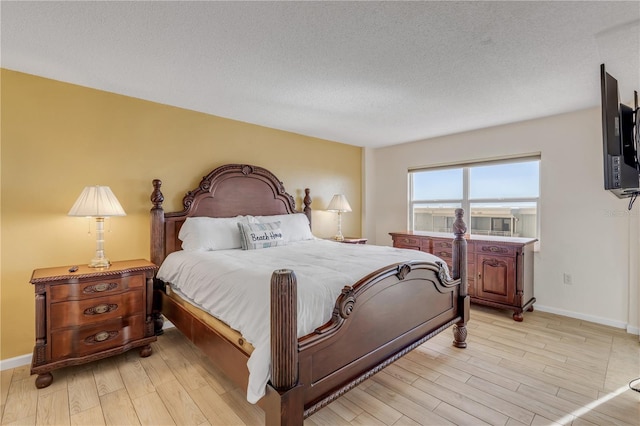 bedroom featuring light hardwood / wood-style floors and a textured ceiling