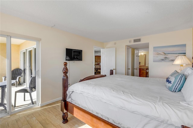 bedroom with access to outside, a textured ceiling, and light wood-type flooring