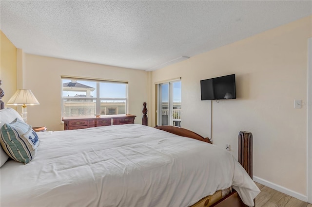 bedroom featuring light hardwood / wood-style floors and a textured ceiling