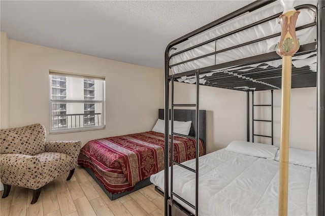 bedroom with hardwood / wood-style floors and a textured ceiling