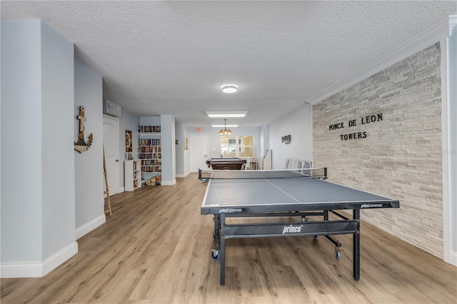 game room featuring crown molding, a textured ceiling, pool table, and light hardwood / wood-style flooring