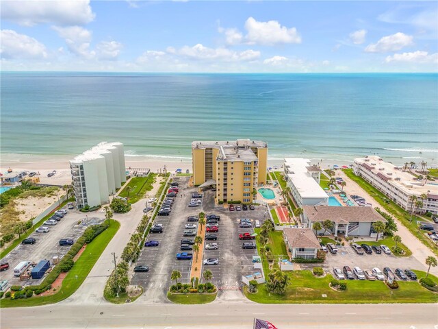 drone / aerial view with a water view and a beach view