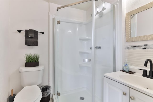 bathroom featuring vanity, an enclosed shower, and toilet