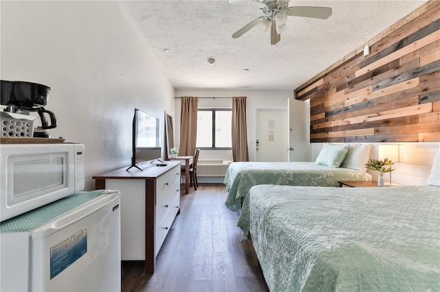 bedroom featuring ceiling fan, dark wood-type flooring, and fridge