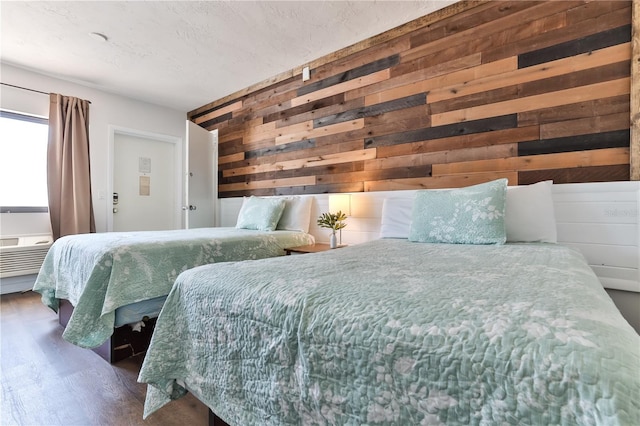 bedroom featuring wooden walls and dark hardwood / wood-style flooring