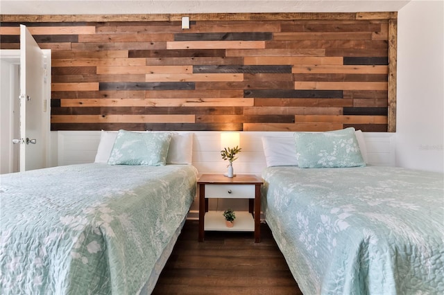 bedroom featuring dark hardwood / wood-style flooring and wood walls