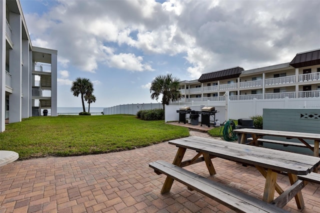 surrounding community featuring a yard, a water view, and a patio