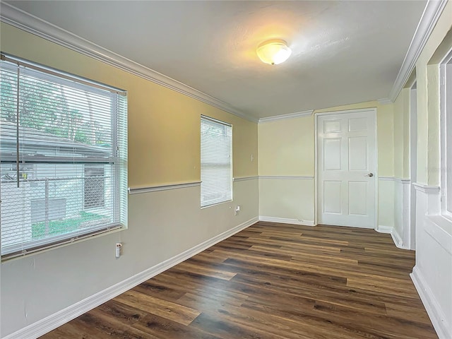 empty room featuring dark hardwood / wood-style floors, a wealth of natural light, and ornamental molding