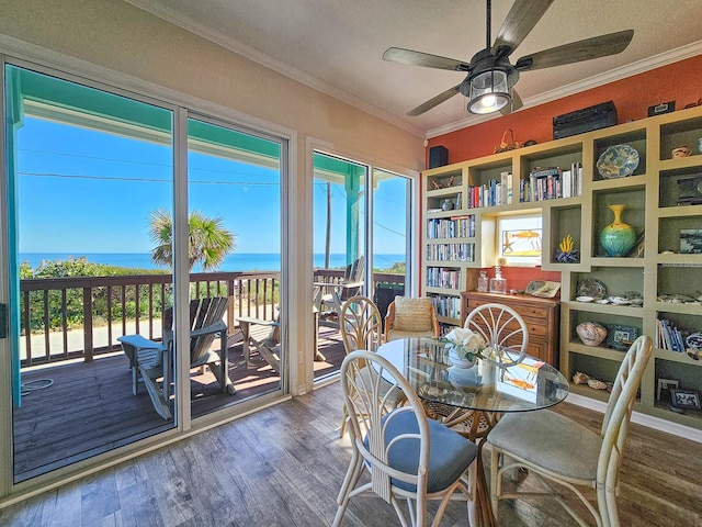 dining room with ceiling fan, hardwood / wood-style floors, a textured ceiling, a water view, and ornamental molding