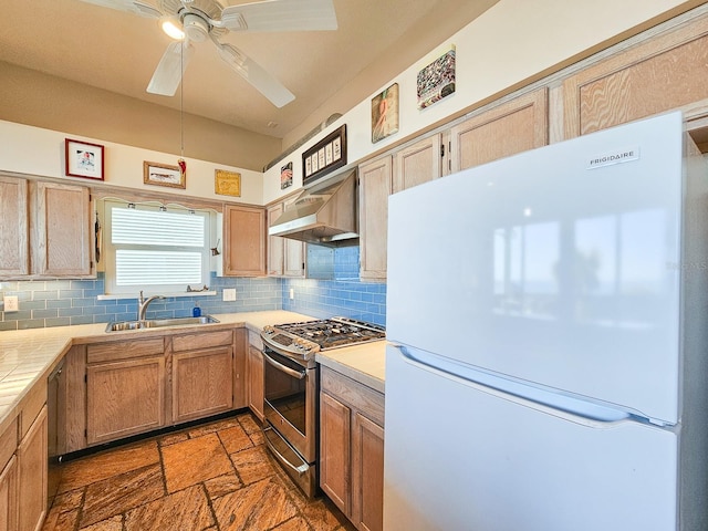 kitchen featuring stainless steel range with gas cooktop, sink, wall chimney exhaust hood, tasteful backsplash, and white fridge