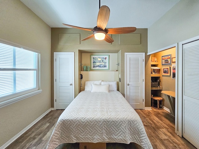 bedroom featuring dark hardwood / wood-style flooring, ceiling fan, and multiple closets