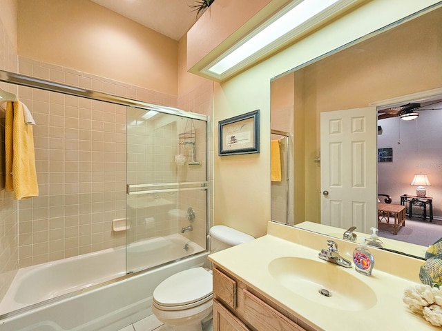 full bathroom featuring bath / shower combo with glass door, vanity, ceiling fan, tile patterned flooring, and toilet