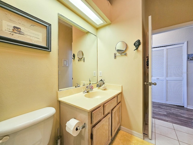 bathroom featuring tile patterned flooring, vanity, and toilet