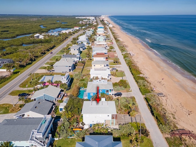 birds eye view of property featuring a water view and a beach view