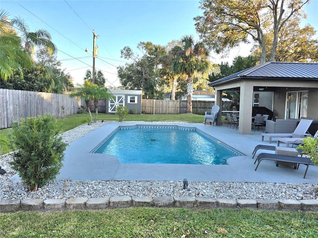 view of swimming pool featuring a storage unit and a patio