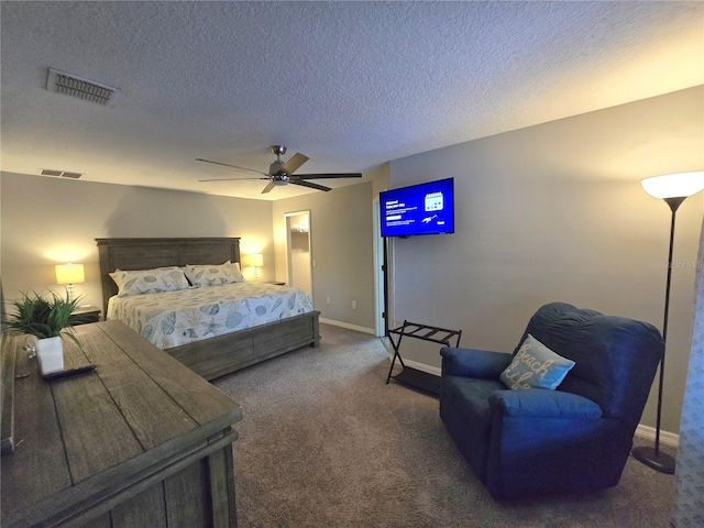 carpeted bedroom featuring ceiling fan and a textured ceiling