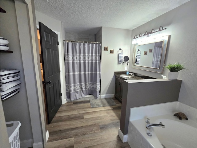 bathroom featuring vanity, shower with separate bathtub, wood-type flooring, and a textured ceiling