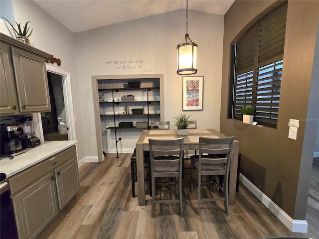 dining space with dark hardwood / wood-style floors and vaulted ceiling