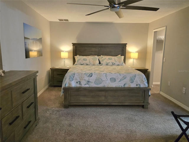 bedroom with ceiling fan, dark carpet, a spacious closet, and a closet