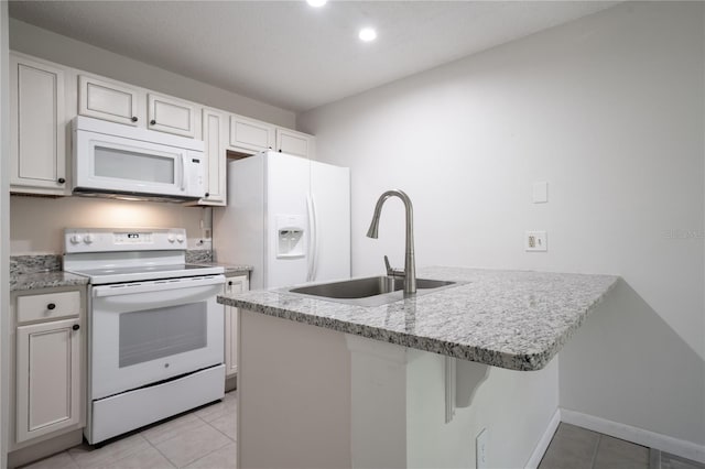 kitchen with white cabinetry, white appliances, sink, and light tile patterned floors