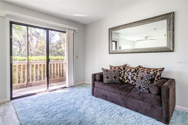 living room with a textured ceiling, hardwood / wood-style flooring, and ceiling fan