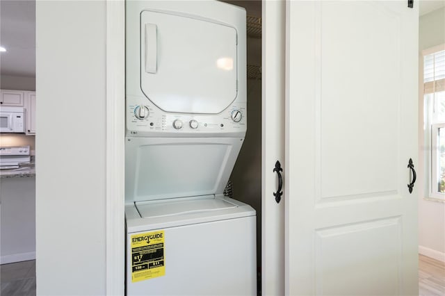 laundry area featuring hardwood / wood-style floors and stacked washer and clothes dryer