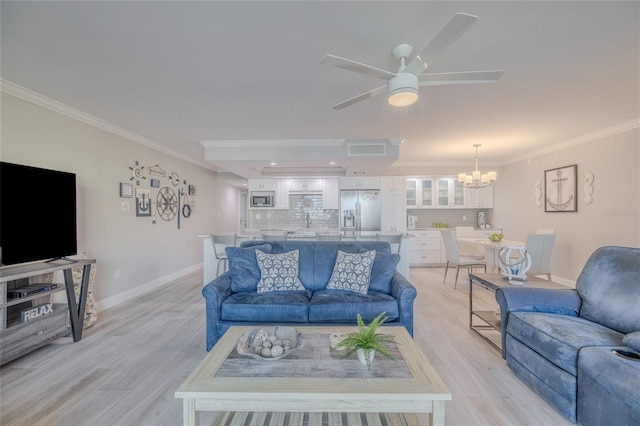 living room with ceiling fan with notable chandelier, light hardwood / wood-style floors, crown molding, and sink